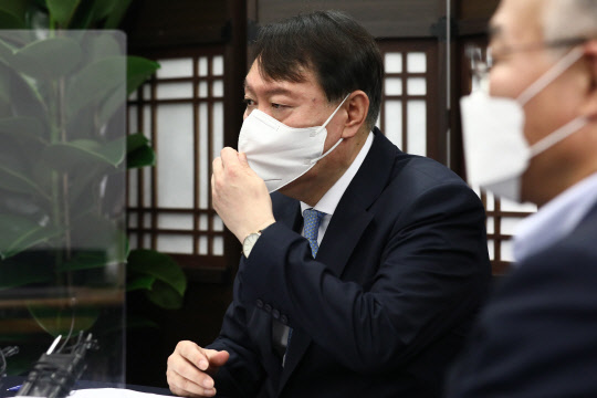 국민의힘 대권주자인 윤석열 전 검찰총장이 12일 서울 종로구 국민캠프에서 열린 코로나19 대책 마련을 위한 전문가 간담회에서 마스크를 고쳐쓰고 있다. 연합뉴스·국회사진기자단